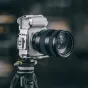 Серебряный корпус Falcam F22 & F38 & F50 для Sony ZV-E1, установленный на черном штативе, с несколькими точками крепления и противоскользящими подушечками.