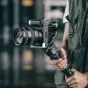 Professional camera mounted on a black L-bracket with a wrist strap, featuring a large lens and stabilizing handle, designed for Sony ZV E1.