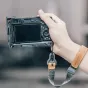 Быстросъемный L-кронштейн Falcam F22 F38 F50 для Sony A7C, закрепленный на камере, держащейся в руке с кожаным ремешком, виден задний LCD экран и кнопки управления