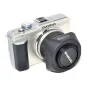 JJC Olympus LH-40 square lens hood for Olympus M.Zuiko 14-42mm lenses, placed beside a silver Olympus mirrorless camera on a white background