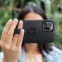 Peak Design case for Apple iPhone 15 Pro Max featuring a magnetic locking mechanism and deployable loop, held by a woman with visible camera module