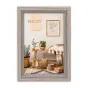 Фотофрейм Zep Italia VZ670A размером 50x70 см с деревянной рамой и стеклом, установлен вертикально на белой стене с минималистичным оформлением.