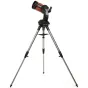 Телескоп Celestron NexStar 5 SE Goto, установленный на прочном штативе, с оранжевой трубой и черной панелью управления с цифровым дисплеем, демонстрирующий свою регулируемую вилочную руку и штативные ноги с резиновыми наконечник