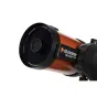 Близкий план передней линзовой сборки телескопа Celestron NexStar 5 SE, черная оптическая труба с оранжевыми акцентами, крышка объектива и брендовая наклейка, установленная на черном штативе с одной вильчатой опорой.