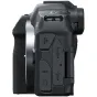 Side view of a black Canon EOS R8 mirrorless camera body, showing the textured grip and rear panel with microphone, headphone, HDMI and USB‑C ports.