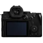 Panasonic Lumix S5M2X mirrorless camera body rear view with partially attached lens, featuring electronic viewfinder, control dials, and touchscreen LCD.