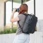 Wandrd PRVKE 31 Zip backpack black in use by photographer with DSLR camera, showcasing rear view with side pockets and top zip access for easy gear organization