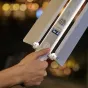 GODOX LED LC500R MINI RGB light tube with handle controls and digital display, adjusting brightness or color temperature in use
