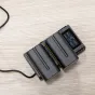 Nitecore NP F Pro Kit with two 5200mAh Sony NP F batteries and USB charger, digital display showing charging status, voltage, current, and capacity