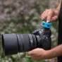 Cyan silicone bumper guard for Westcott FJ T1 Wireless Trigger, protecting the trigger on a Nikon DSLR camera during outdoor photography.
