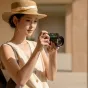 Fujifilm X100VI с конвертационным телеобъективом Viltrox TCL X100VI для увеличения фокусного расстояния в 1.4 раза, демонстрирующий компактный дизайн и оптическую четкость на улице