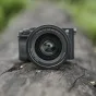 Viltrox AF 35mm F/1.2 LAB objektīvs Sony E-mount ar lielu atvērturi un kvalitatīvu metāla konstrukciju uz dabīgas koka virsmas