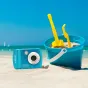DiFox Aquapix W3027 Wave waterproof camera in ice blue color on sandy beach with sand bucket and shovel
