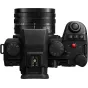 Panasonic Lumix DC-S5 IIX bezspoguļu kamera ar 18-40mm objektīvu no augšas, redzams režīmu slēdzis, kontrolēšanas ratiņš un objektīva atzīmējumi daudzpusīgai fotografēšanai un videofilmēšanai