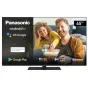 Panasonic 65 colu Android TV TX-65LX650E, kas attēlo dzīvesveida ainu ar pāri, kas bauda popkornu, ar Android TV, OK Google, integrētu Chromecast, Google Play, Dolby Vision Atmos, spēļu režīmu un Bluetooth mājīgā viesistabā.