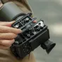 Tilta Sony FX2 kameras aizsardzības kārba titāna pelēkā krāsā ar NATO slieksni, auksto pēdu un vītņotiem montāžas punktiem – augšējais skats, kas parāda kabeļu fiksatorus un papildus ierīču piestiprināšanas punktus