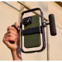 Moment Basecage aluminum smartphone rig with NATO rails and Arca-type dovetail base, securely holding an iPhone with an external microphone attached to the side rail