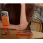 Ulanzi PS01 MagSnap phone stand in vibrant orange with a MagSafe-compatible smartphone securely held in a foldable magnetic holder, ideal for hands-free use and travel.