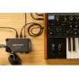 Zoom UAC-232 USB audio converter connected to a synth keyboard and headphones, designed for professional audio production with 32-bit floating point recording.