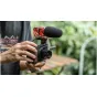 Tilta vintage camera cage for Canon PowerShot V1 with wooden handle, Cold Shoe adapter, and furry windscreen microphone setup in an outdoor setting