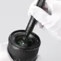 Ulanzi CO26 camera cleaning kit in use, with a cleaning brush inserted into the lens mount of an APS-C camera body, demonstrating effective maintenance for sensors and lenses.