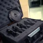 Комплект диоптров Vaxis VFX 114мм с четырьмя маркированными элементами в защитном кейсе, размещен на улице рядом со зданием.