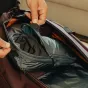 Peak Design Packing Cube Small okeāna krāsā ar atšķirāmu zipu atvērtu, rādot divus nodalījumus un iekšējo šķērsli efektīvai ceļojuma iepakošanai.