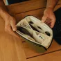 Peak Design Tech Pouch Small в цвете морская водоросль с открытым видом, демонстрирующим организованное 12-карманное внутреннее содержимое с кабелями, картами памяти и флеш-накопителем.