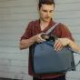 Peak Design Everyday Totepack V2 20L ocean backpack with dual side zippers, holding a professional camera for versatile outdoor photography storage