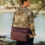 Peak Design Everyday Sling V2 10L eclipse modelis, nēsāts priekšā, ar aizsardzību pret apstākļiem UltraZip, ideāli piemērots 13 collu laptopa un fotoaparātu pārvadāšanai.