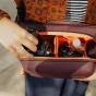 Сумка Peak Design Everyday Sling V2 3L в открытом виде с объективом фотоаппарата внутри, демонстрирующая мягкие перегородки и компактное хранение для фототехники в поездках