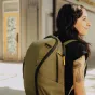 Peak Design Everyday Backpack Zip V2 20L zāļu zaļā krāsā ar visapkārtējo zip atvēršanu, valkāts pilsētvidē