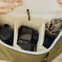 Рюкзак Peak Design Everyday Backpack V2 30L в цвете келп с фотокамерой Fujifilm, надежно размещенной в мягком отсеке, демонстрирующий внутреннюю организацию и защиту от погоды с помощью молний UltraZip