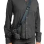 Peak Design Slide Lite Ocean camera strap with Anchor Link system attached to a camera, shown in versatile sling mode across a dark long-sleeved shirt.
