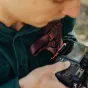 Peak Design Capture Clip V3 secured on camera strap with quick-release mechanism in use, showcasing compact aluminum build and weatherproof design