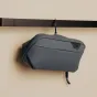 Компактный туалетный мешок Peak Design Wash Pouch S в темно-синем цвете, подвешенный на крючке, для организации гигиенических принадлежностей в поездках.
