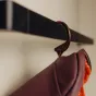 Peak Design Wash Pouch S burgundy toiletry bag hanging on a stowable aluminum hook, compact travel essentials organizer with durable weatherproof materials