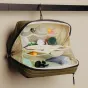 Открытый туалетный мешок Peak Design Wash Pouch в цвете kelp с организованными средствами гигиены в сетчатых и молниевых отсеках.