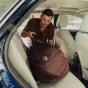 Peak Design Travel Duffel 65L lietojumā – ietilpīga 65L ceļojuma soma ar ūdensizturīgu UltraZip, apmīkstinātiem rokturiem un noņemamu plecu jostu, atvērta automašīnā, lai uzglabātu aprīkojumu