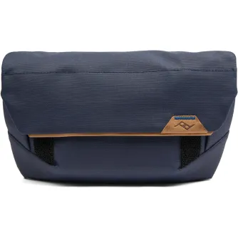 Peak Design Field Pouch V2 in dark blue, featuring a weatherproof nylon exterior, a roll-top hook-and-loop closure, and a stowable adjustable strap for versatile carrying options.