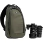Think Tank TurnStyle 11L virsējo somu zaļā krāsā ar melnu apdari, blakus Nikon DSLR kamerai un objektīviem, demonstrējot profesionālu aprīkojumu fotogrāfiem.