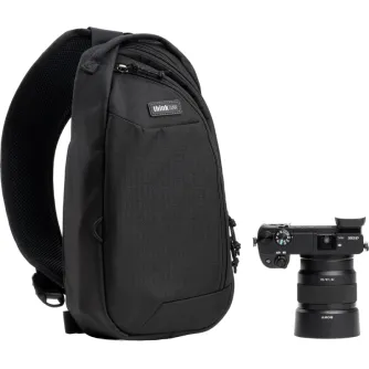 Melns Think Tank TurnStyle 5L sliņs bāgs ar redzamu logotipu, izstrādāts fotogrāfiem, ar sietu aizmugurē, mīkstu plecu siksnu un vairākiem rāvējslēdzējiem, novietots blakus Sony kamerai ar objektīvu.