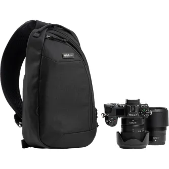 Melns Think Tank TurnStyle 8L sling bags ar Nikon DSLR kameru un objektīvu priekšējā nodalījumā.