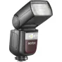 Godox Speedlite V860III Nikon zibspuldze uzstādīta kamerā karstajā pēdā, nedaudz pacelta uz augšu, redzama priekšējā difuzora daļa. Zibspuldze ir melnā krāsā ar sarkanu akcentu paneli, uz kura redzams 'Godox' logo, ir ieslēgta L
