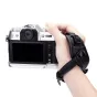 JJC HG XT50 SILVER Camera Hand Grip with black silicone wrist strap securely fitted on a hand holding a Fujifilm X‑T50 camera