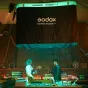 Godox AM1600R 48K KNOWLED Гибкий LED RGB Mat 4x8 софтбокс с надувным бабочковым каркасом, освещённый в студийной сцене с двумя техниками у рабочего стола.