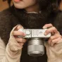 Объектив Viltrox AF 35mm F/1.7 Fuji X Silver установлен на корпусе камеры с интерфейсом X-mount, с детализированным кольцом диафрагмы с маркировкой F1.7, текстурированной зоной захвата и прикрепленным блендой. Корпус камеры с бр