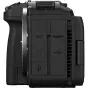 Tuvplāns Canon EOS R6 V aizmugures panelim, kurā redzami porti un pogas. Melna kamera ar teksturētu rokturi, marķētiem HDMI, mikrofona ieejas, USB-C un austiņu ligzdām, kā arī ventilācijas režģis un skrūves, kas nostiprina panel