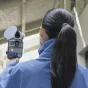XGRIDS Lixel L2 Pro handheld LiDAR scanner with 16-channel sensor module, real-time 3D scanning capabilities, and protective case in an industrial environment