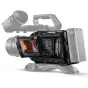 Close-up of Blackmagic URSA Mini Pro 12K OLPF camera on a tripod, featuring a 4-inch LCD touchscreen displaying a live feed, large lens with 29mm focal length, top handle, and battery grip with visible control buttons and ports 